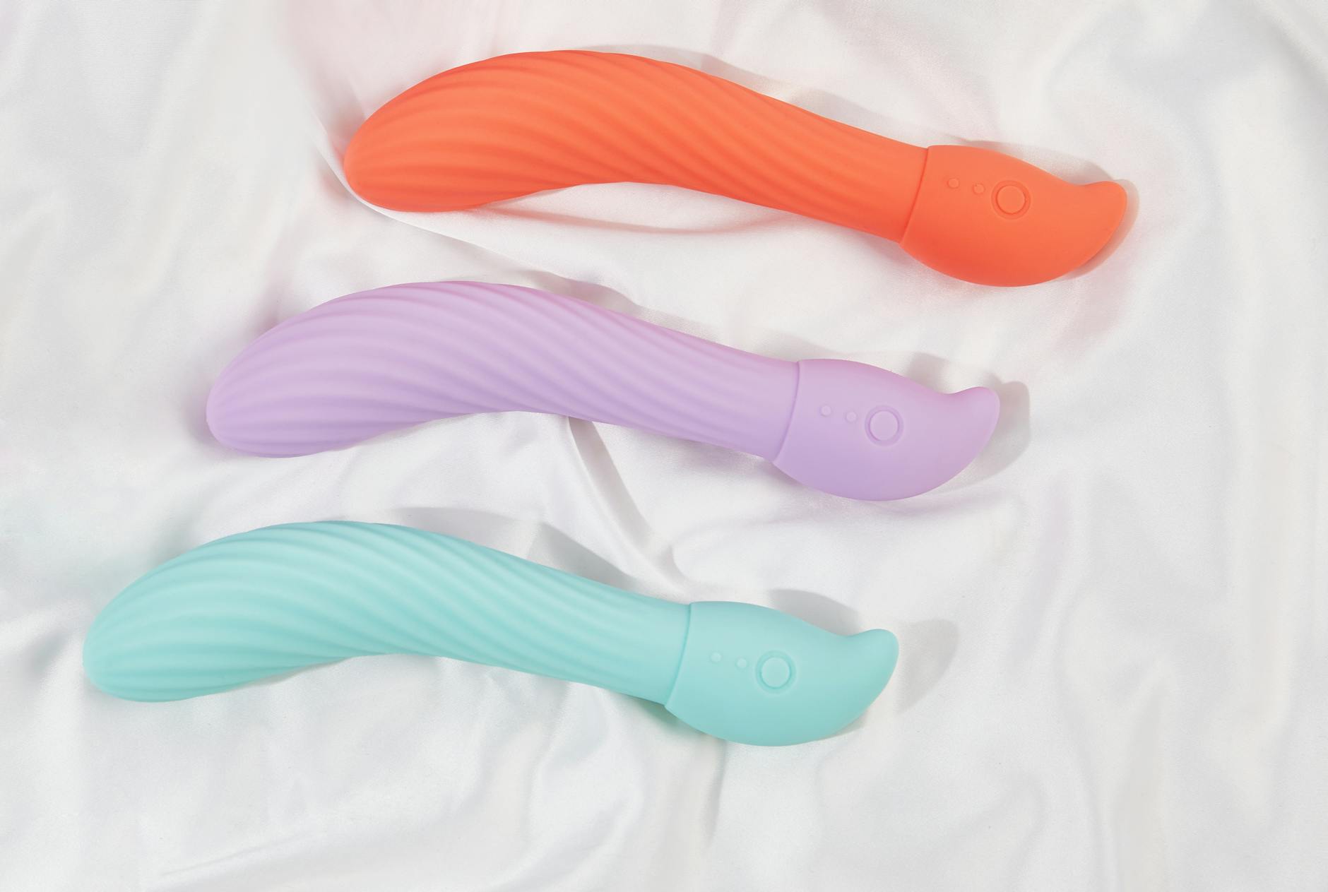 A young couple holding a blue vibrator together indoors, representing modern long-distance intimacy.