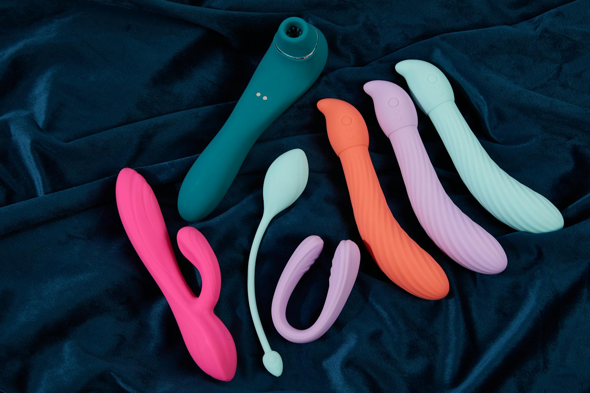 Pink vibrator surrounded by heart confetti and candles, symbolizing intimate couples exploration