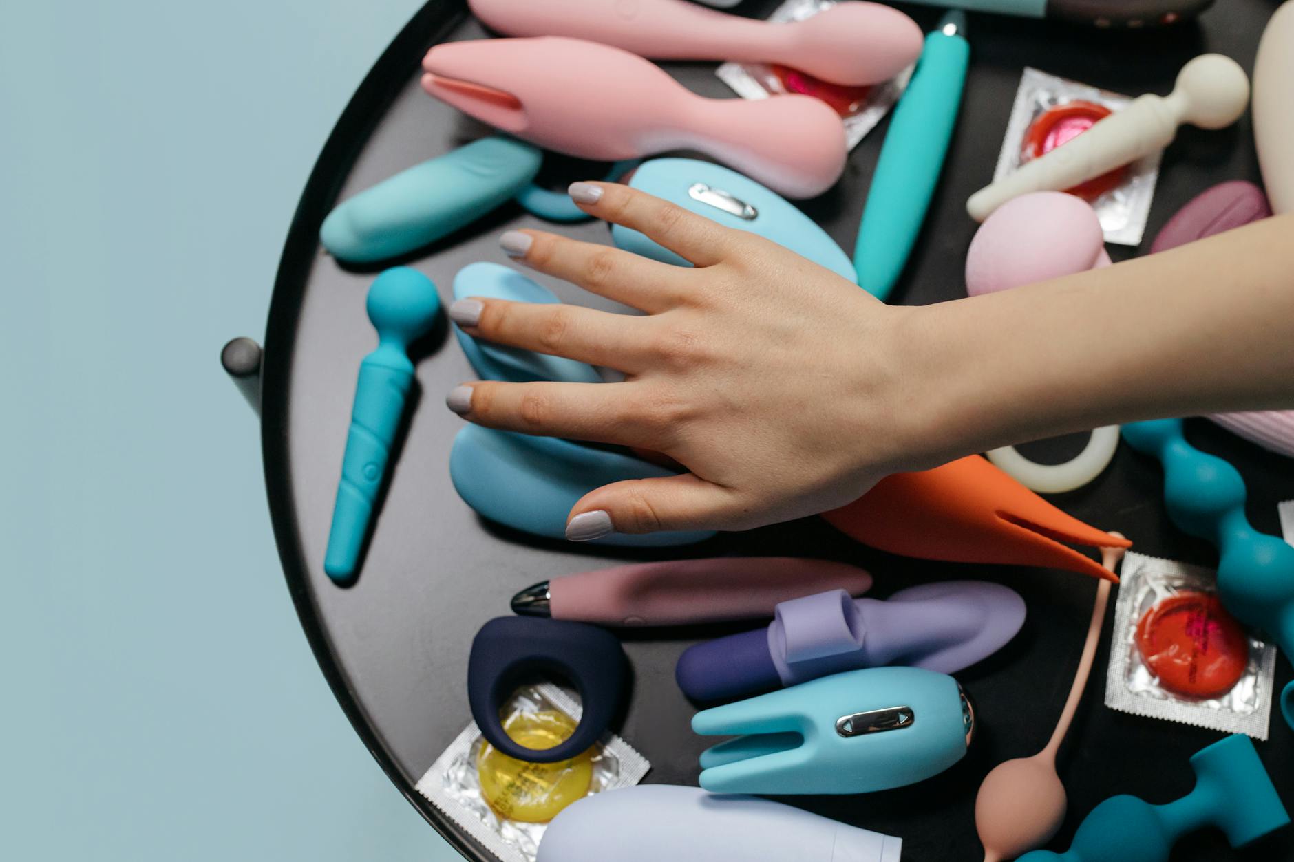 Close-up of hands holding a sleek lemon vibrator against a purple background.