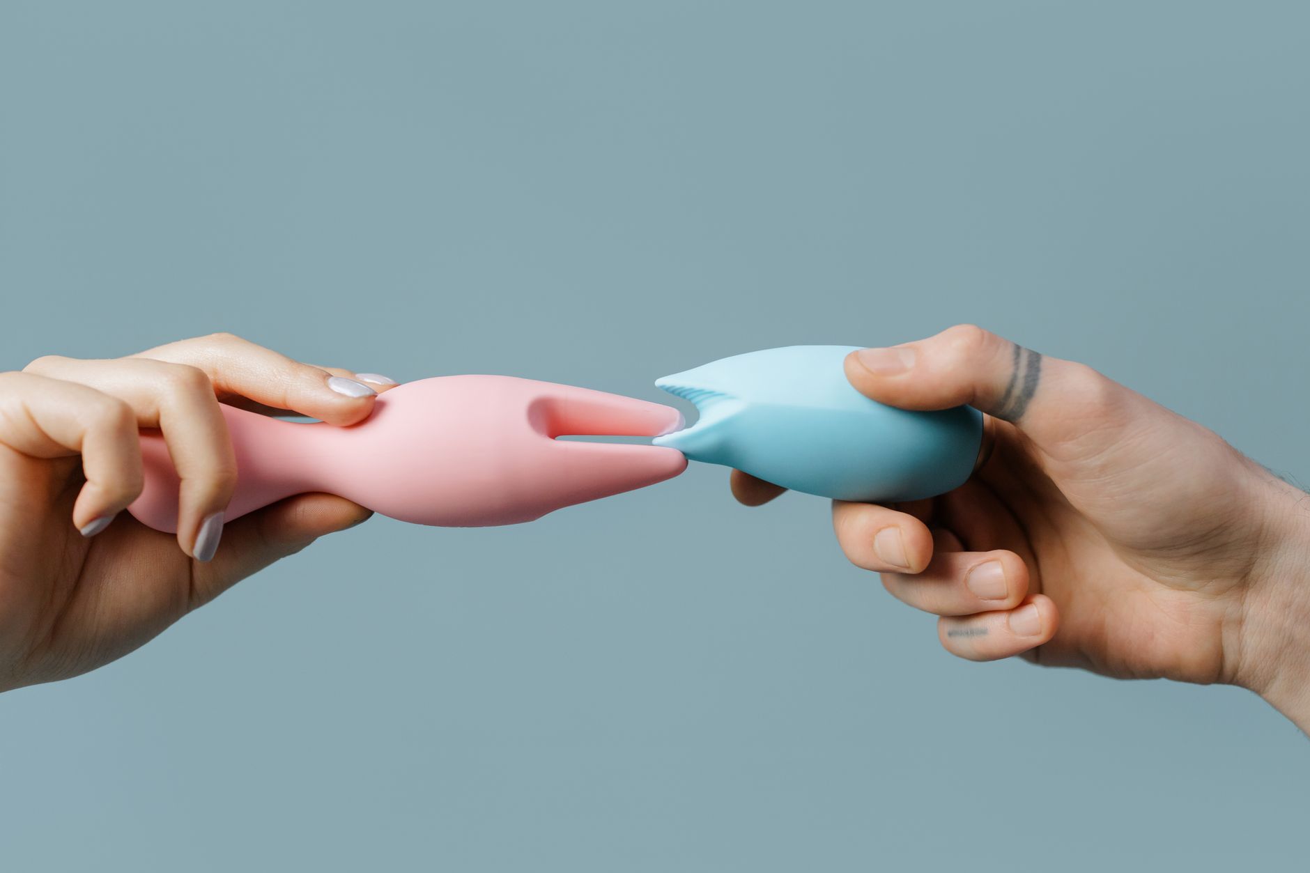 Hands holding pastel-colored silicone toys, perfect for adult and lifestyle themes.