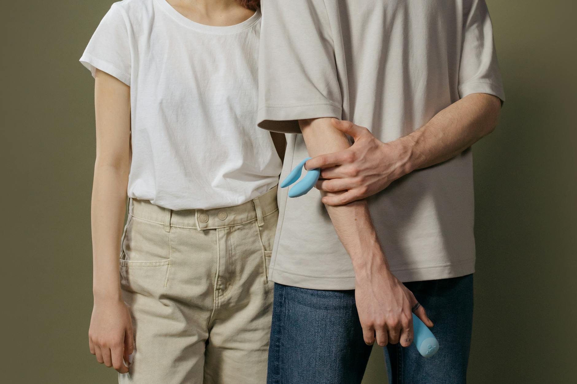 A person holding a blue lemon vibrator indoors, representing intimate self-care and stress relief