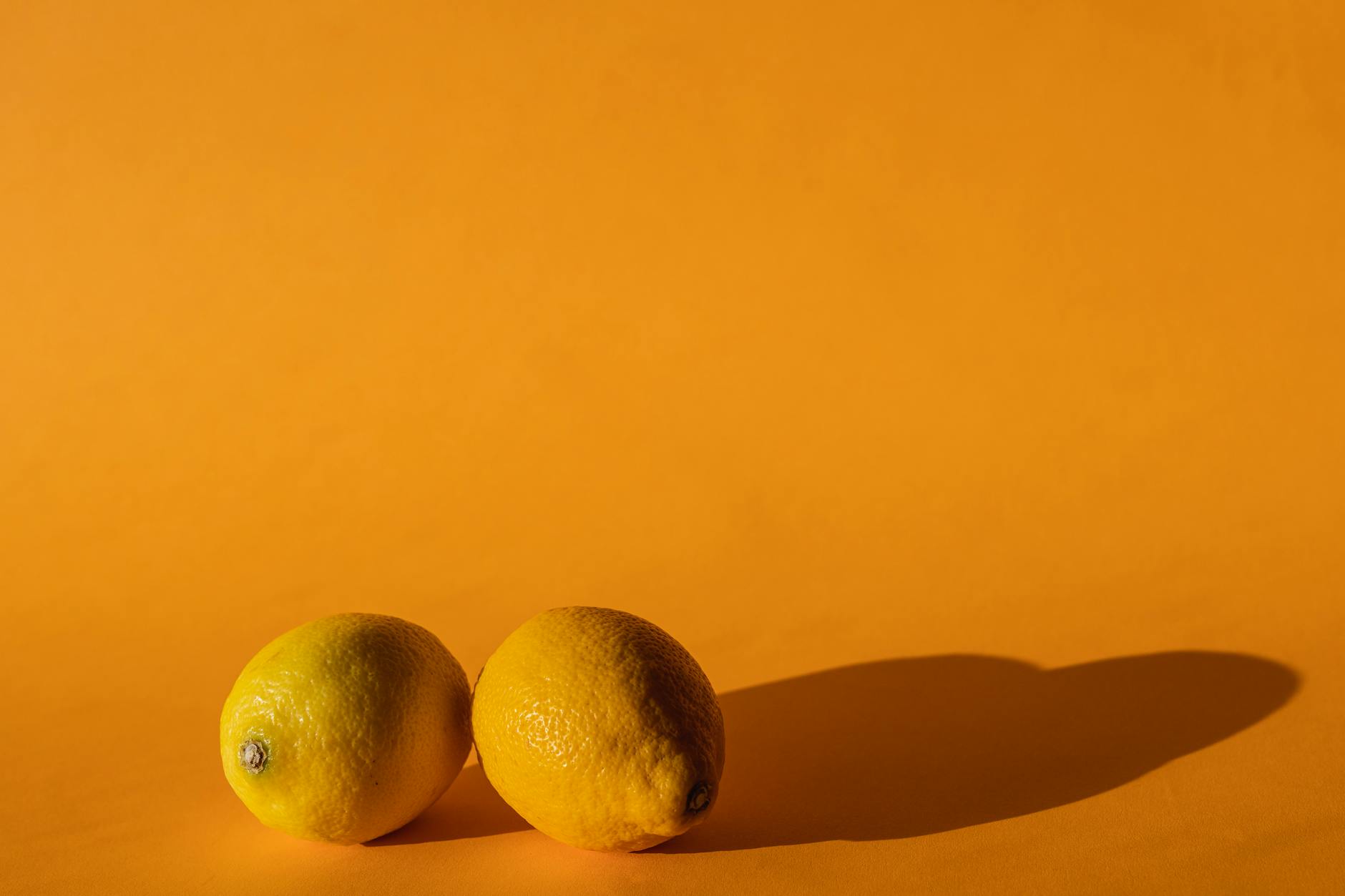 Ripe vivid lemons on a bright yellow background, symbolizing pleasure and sensory richness